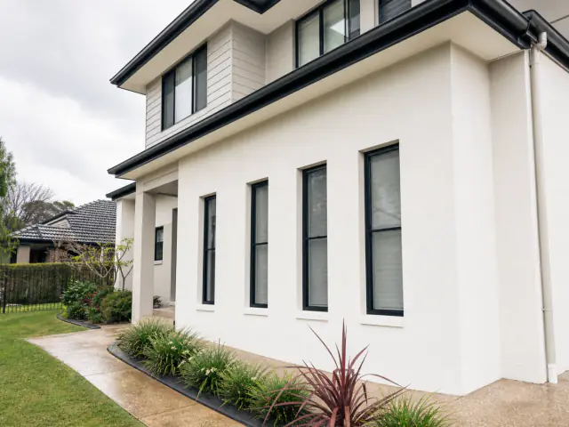 Freshly soft-washed two-storey Brisbane home exterior with clean rendered walls and no equipment visible