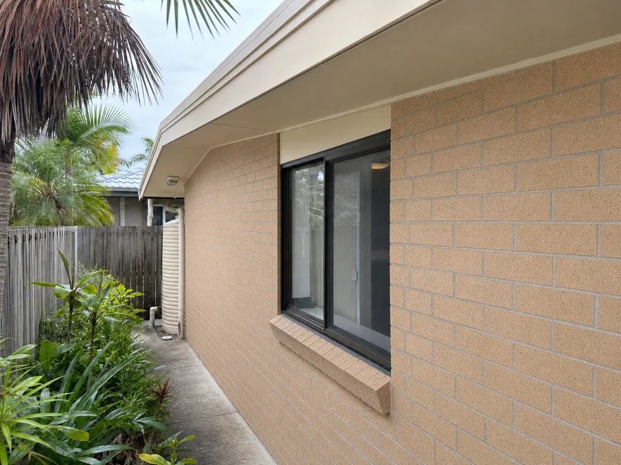 Low-set Brisbane brick home after soft washing, with clean eaves and brickwork